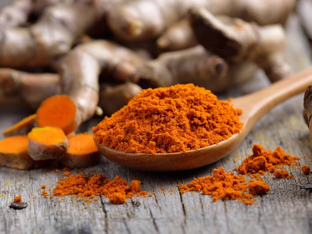 ingredients to ward off infection pile of fresh turmeric roots on wooden table